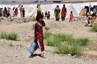 A flood victim walks to get drinking water at a relief camp in Dasht near Quetta, Pakistan, Friday, Sept. 16, 2022. The devastating floods affected over 33 million people and displaced over half a million people who are still living in tents and make-shift homes. The water has destroyed 70% of wheat, cotton and other crops in Pakistan. (AP Photo/Arshad Butt)