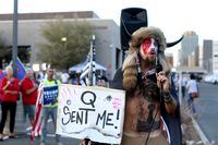 A Qanon believer speaks to a crowd of President Donald Trump supporters outside of the Maricopa County Recorder's Office where votes in the general election are being counted, in Phoenix, Thursday, Nov. 5, 2020. (AP Photo/Dario Lopez-MIlls)