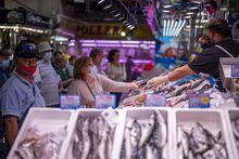 FILE - A customer pays for fish at the Maravillas market in Madrid, on May 12, 2022. Europe's painful inflation inched higher last month, extending the squeeze on households and keeping pressure on the European Central Bank to unleash another large interest rate increase. Consumer prices jumped 7% in April from a year earlier, just down from the annual rate of 6.9% in March, the European Union statistics agency Eurostat said Tuesday May 2, 2023. (AP Photo/Manu Fernandez, File)