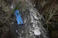 TOPSHOT - The wreck of a bus lies in the Lerez river after it plunged while crossing a bridge, killing four people, in Cerdedo-Cotobade, northwestern Spain, on December 25, 2022. - The accident occurred on December 24 night near Vigo and the border with Portugal. The regional La Voz de Galicia newspaper said the bus was carrying people visiting their loved ones jailed in Monterroso in central Galicia. Rescue operations had to be suspended overnight due to bad weather but resumed in the morning. (Photo by Brais Lorenzo / AFP) (Photo by BRAIS LORENZO/AFP via Getty Images) *** BESTPIX ***