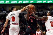 Toronto Raptors' O.G. Anunoby (3) goes up for a shot against Chicago Bulls' DeMar DeRozan (11) and Zach LaVine (8) during the first half of an NBA basketball game Monday, Nov. 7, 2022, in Chicago. (AP Photo/Paul Beaty)