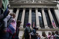 A tour group stops in front of the New York Stock Exchange in New York, Tuesday, June 14.