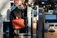 FILE PHOTO: A passenger weighs luggage at John F. Kennedy International Airport during the spread of the Omicron coronavirus variant in Queens, New York City, U.S., December 26, 2021. REUTERS/Jeenah Moon