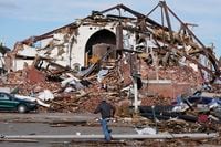 People survey damage from a tornado is seen in Mayfield, Ky., on Saturday, Dec. 11, 2021. Tornadoes and severe weather caused catastrophic damage across multiple states late Friday, killing several people overnight. (AP Photo/STF