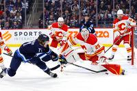 Jan 3, 2023; Winnipeg, Manitoba, CAN; Winnipeg Jets left wing Axel Jonsson-Fjallby (71) shoots on Calgary Flames goaltender Jacob Markstrom (25) in the second period at Canada Life Centre. Mandatory Credit: James Carey Lauder-USA TODAY Sports