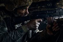 A Ukrainian soldier of the 28th brigade fires on the frontline during a battle with Russian troops at the frontline near Bakhmut, Donetsk region, Ukraine, Friday, March 24, 2023. (AP Photo/Libkos)