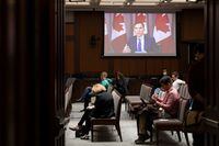 Reporters listen as Finance Minister Bill Morneau responds to a question via video conference, during a news conference in Ottawa, on May 15, 2020.
