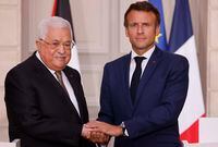 Palestinian President Mahmoud Abbas, left, shakes hands with French President Emmanuel Macron during a meeting at the Elysee Palace in Paris, Wednesday, July 20, 2022. (Ludovic Marin/Pool via AP )