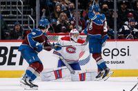 Jan 22, 2022; Denver, Colorado, USA; Colorado Avalanche left wing Gabriel Landeskog (92) is hit by the puck as he screens Montreal Canadiens goaltender Cayden Primeau (30) as center Alex Newhook (18) looks on in the third period at Ball Arena. Mandatory Credit: Isaiah J. Downing-USA TODAY Sports