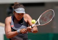 Japan's Naomi Osaka returns the ball to Romania's Patricia Maria Tig during their first round match of the French open tennis tournament at the Roland Garros stadium Sunday, May 30, 2021 in Paris. (AP Photo/Christophe Ena)