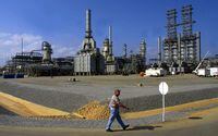 FILE PHOTO: A worker walks past the Petrozuata Oil Refinery in the Orinoco oil belt in the Venezuelan eastern state of Anzoategui, February 13, 2001./File Photo
