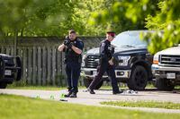A police officer takes photographs at the scene of a homicide investigation in the area of Jones Road and Barton Street in Hamilton, Ont. Sunday, May 28, 2023. Police say three people are dead following landlord-tenant dispute that became a stand off at a residence late Saturday. THE CANADIAN PRESS/Nick Iwanyshyn