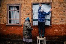 Elderly women placard a plastic sheet over a broken windows after shelling in Chasiv Yar, near Bakhmut on February 28, 2023, amid Russia's military invasion on Ukraine. - Ukraine said on February 28, its forces were under pressure in Bakhmut, a nearly-destroyed city in the eastern Donetsk region that Russia has been trying to seize for months. (Photo by Dimitar DILKOFF / AFP) (Photo by DIMITAR DILKOFF/AFP via Getty Images)