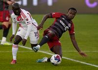 Toronto FC midfielder Richie Laryea (22) goes to ground to control the ball as New England Revolution midfielder Ema Boateng (18) defends during first half MLS soccer action in Toronto on Saturday May 6, 2023. THE CANADIAN PRESS/Frank Gunn
