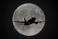FILE PHOTO: A passenger plane is seen with the moon behind as it begins its final landing approach to Heathrow Airport in London, Britain, September 25, 2018. REUTERS/Toby Melville