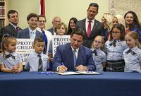 FILE - Florida Gov. Ron DeSantis signs the Parental Rights in Education bill at Classical Preparatory school, on March 28, 2022, in Shady Hills, Fla. The Walt Disney Company announced late Sunday, Nov. 20, 2022, that former CEO Bob Iger will return to head the company for two years in a move that stunned the entertainment industry. Disney said in a statement that Bob Chapek, who succeeded Iger in 2020, had stepped down from the position. Chapek faced blowback early this year for not using Disney's vast influence in Florida to quash the Republican bill that would prevent teachers from instructing early grades on LGBTQ issues. (Douglas R. Clifford/Tampa Bay Times via AP, File)