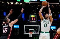 Boston Celtics forward Jayson Tatum (0) shoots over Miami Heat forward Caleb Martin (16) during the second half of Game 4 of the NBA basketball playoffs Eastern Conference finals, Monday, May 23, 2022, in Boston. (AP Photo/Charles Krupa)