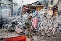 A soldier walks past wreckage in the aftermath of an attack on the Afrik hotel in Mogadishu, Somalia, Monday, Feb. 1, 2021.