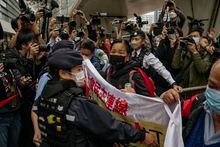 Photographers take picture of the members of League of Social Democrats scuffling with police outside the West Kowloon Magistrates' Courts ahead of the national security trail for the pro-democracy activists in Hong Kong, Monday Feb. 6, 2023. Some of Hong Kong's best-known pro-democracy activists went on trial Monday in the biggest prosecution yet under a law imposed by China's ruling Communist Party to crush dissent. (AP Photo/Anthony Kwan)