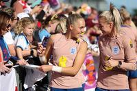 England's goalkeeper Ellie Roebuck and defender Alex Greenwood, right, react with fans at Central Coast Stadium in Gosford, Australia, Tuesday, July 25, 2023. England ranks second only to the United States in Women's World Cup ticket sales for countries outside of Australia and New Zealand. (AP Photo/Jessica Gratigny)