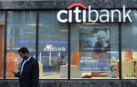 (FILES) In this file photo taken on October 5, 2016 a man checks his phone near a Citibank branch in Washington, DC. - US authorities fined Citibank $400 million over deficiencies in risk management practices and required an overhaul of internal controls at the global financial powerhouse, officials announced on October 7, 2020. The US Treasury's Office of the Comptroller of the Currency issued the fine, in parallel with a related action from the Federal Reserve citing failings at the bank. (Photo by ANDREW CABALLERO-REYNOLDS / AFP) (Photo by ANDREW CABALLERO-REYNOLDS/AFP via Getty Images)