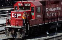 A Canadian Pacific Railway employee walks along the side of a locomotive in a marshalling yard, in Calgary, on May 16, 2012.