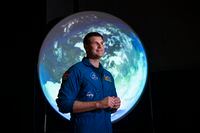 Canadian Space Agency astronaut Jeremy Hansen stands in front of a display as he participates in an interview at the opening of Earth in Focus: Insights from Space, a new exhibition at the Canada Science and Technology Museum in Ottawa, on Friday, Nov. 26, 2021. Before Hansen gets a chance to wear Canada's colours on a flight around the moon next year, he will carry the Canadian flag at the coronation of the country's new King. THE CANADIAN PRESS/Justin Tang