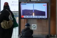 A TV screen shows a file image of North Korea's rocket with the test satellite during a news program at the Seoul Railway Station in Seoul, South Korea, Saturday, Dec. 31, 2022. North Korea fired three short-range ballistic missiles toward its eastern waters on Saturday, the latest in a barrage of weapons tests this year that came days after it increased tensions by allegedly flying drones into South Korean airspace. (AP Photo/Lee Jin-man)