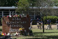 FILE - Investigators search for evidence outside Robb Elementary School in Uvalde, Texas, May 25, 2022, after an 18-year-old gunman killed 19 students and two teachers. The city of Uvalde sued the local prosecutor's office Thursday, Dec. 1, 2022 seeking access to records and other investigative materials on the May shooting at the elementary school, highlighting ongoing tensions over the slow police response and resulting flow of information about the rampage. (AP Photo/Jae C. Hong, File)
