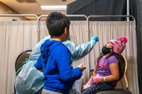Addison Moonias, 5, of Neskantaga First Nations is swabbed for Covid-19 before she and her family head home for the holidays after nearly two months of being evacuated to Thunder Bay, Ontario, due to a water crisis. David Jackson / The Globe and Mail