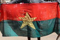 A man holds his national flag to show support for the military after Burkina Faso President Roch Kabore was detained at a military camp in Ouagadougou, Burkina Faso, January 24, 2022. REUTERS/Vincent Bado