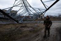 A Ukrainian soldier walks under a communications tower that fell from a strike, as Russia's attack on Ukraine continues, during intense shelling in Yampil, Ukraine, December 28, 2022. REUTERS/Clodagh Kilcoyne