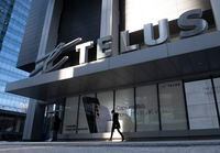 A woman walks in front of the Telus head office is shown in Toronto on Thursday, February 11, 2021.  Telus Corp. wants to pass on credit card fees to customers, and plans to tack on a 1.5 per cent "processing fee" starting this fall. THE CANADIAN PRESS/Frank Gunn