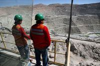 Workers of BHP Billiton's Escondida, the world's biggest copper mine, are seen in front of the open pit, in Antofagasta, northern Chile March 31, 2008.