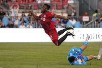 CF Montréal goalkeeper James Pantemis (41) makes a save as Toronto FC forward Ayo Akinola (20) jumps over him avoiding a collision during second half Voyageurs Cup semifinal soccer action against CF Montréal in Toronto on Wednesday, June 22, 2022. THE CANADIAN PRESS/Nathan Denette