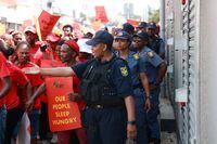 Members of the South African Police Services (SAPS) guide members of the Economic Freedom Fighters (EFF) as they march through the streets in central Durban on March 20, 2023,  during a "national shut-down" called by their party. (Photo by RAJESH JANTILAL / AFP) (Photo by RAJESH JANTILAL/AFP via Getty Images)