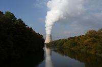 The Isar Nuclear Power Plant reflects on the water surface of the river Isar as steam arises from the cooling tower in Essenbach near Landshut, southern Germany, on October 12, 2022. - Germany recently announced to keep two nuclear power plants on standby until April 2023, in a landmark U-turn. (Photo by Christof STACHE / AFP) (Photo by CHRISTOF STACHE/AFP via Getty Images)