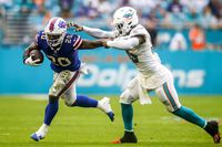 Buffalo Bills running back Zack Moss (20) protects the ball from Miami Dolphins outside linebacker Jerome Baker (55) during the third quarter of the game at Hard Rock Stadium in Miami on Sept. 19, 2021.