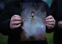 A friend holds a photograph of Ethan Bespflug, 17, who died after being stabbed on a transit bus last week, during a vigil in Surrey, B.C., on Tuesday, April 18, 2023. Police say they have arrested a 20-year-old man from Burnaby, B.C., in connection with the stabbing of a teenager on a Metro Vancouver transit bus last week. THE CANADIAN PRESS/Darryl Dyck