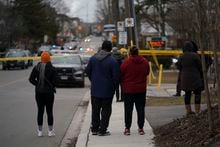 Family members of a student wait at the scene of a shooting at a high school in Toronto on February 16, 2023. Police say one person was shot at Weston Collegiate Institute during the lunch break on Thursday. THE CANADIAN PRESS/Arlyn McAdorey