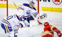 Edmonton Oilers goalie Stuart Skinner, centre, grabs a shot from Calgary Flames forward Nazem Kadri, right, as defenceman Markus Niemelainen looks on during second period NHL hockey action in Calgary, Tuesday, Dec. 27, 2022.THE CANADIAN PRESS/Jeff McIntosh