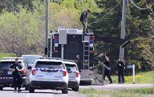 OPP officers set up a mobile support unit near the scene of a shooting where one Ontario Provincial Police officer was killed and two others injured in the town of Bourget, Ont. on Thursday, May 11, 2023. THE CANADIAN PRESS/ Patrick Doyle