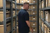 Canadian William Wiley walks among the archive of 800,000 documents he and his team have collected, smuggled out of Syria, that he says prove Bashar al-Assad is personally responsible for war crimes such as systematic torture and murder in detention.