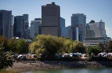 Tents are seen at a homeless encampment at Crab Park as the downtown skyline rises behind them in Vancouver, on Sunday, August 14, 2022. Police say one suspect is in custody after a "stabbing spree" in downtown Vancouver’s Crab Park. THE CANADIAN PRESS/Darryl Dyck