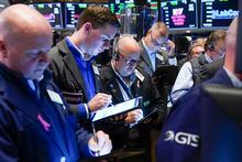 Traders gather around a post as Twitter shares resume trading on the floor at the New York Stock Exchange in New York, Tuesday, Oct. 4.