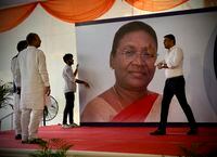 Workers put up a giant hoarding of Droupadi Murmu for her felicitation, before she was announced as the country's new President, in New Delhi, India, Thursday, July 21, 2022. Murmu, who hails from a minority ethnic community, was chosen Thursday as India’s new president, a largely ceremonial position. (AP Photo/Manish Swarup)