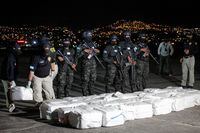 FILE PHOTO: Officers of Honduras' Technical Agency for Criminal Investigation carry a package containing cocaine seized during a police operation, at a presentation to the media, in Tegucigalpa, Honduras December 11, 2022. REUTERS/Fredy Rodriguez