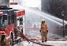 Firefighters are shown at the scene of a fire in Old Montreal, Thursday, March 16, 2023. Residents have been evacuated and multiple people have been treated for injuries. THE CANADIAN PRESS/Graham Hughes 