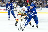 Toronto Maple Leafs' Morgan Rielly battles for the puck with Vegas Golden Knights' Michael Amadio during first period NHL hockey action in Toronto, on Tuesday, February 27, 2024.THE CANADIAN PRESS/Chris Young