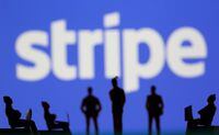 Small toy figures are seen in front of Stripe logo in this illustration picture taken March 15, 2021.